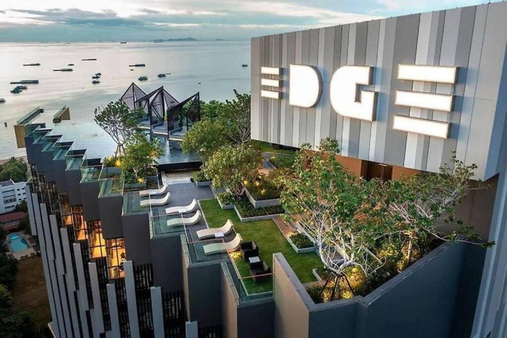 uma vista superior de um edifício com cadeiras e árvores em Edge Seaside Luxury Stylish Condo steps away from beach em Pattaya Central