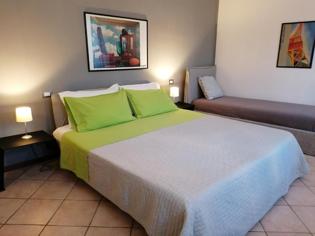 una camera da letto con un grande letto con cuscini verdi di Sulla strada per il lago CIR - O17161CNI00001 a Rezzato