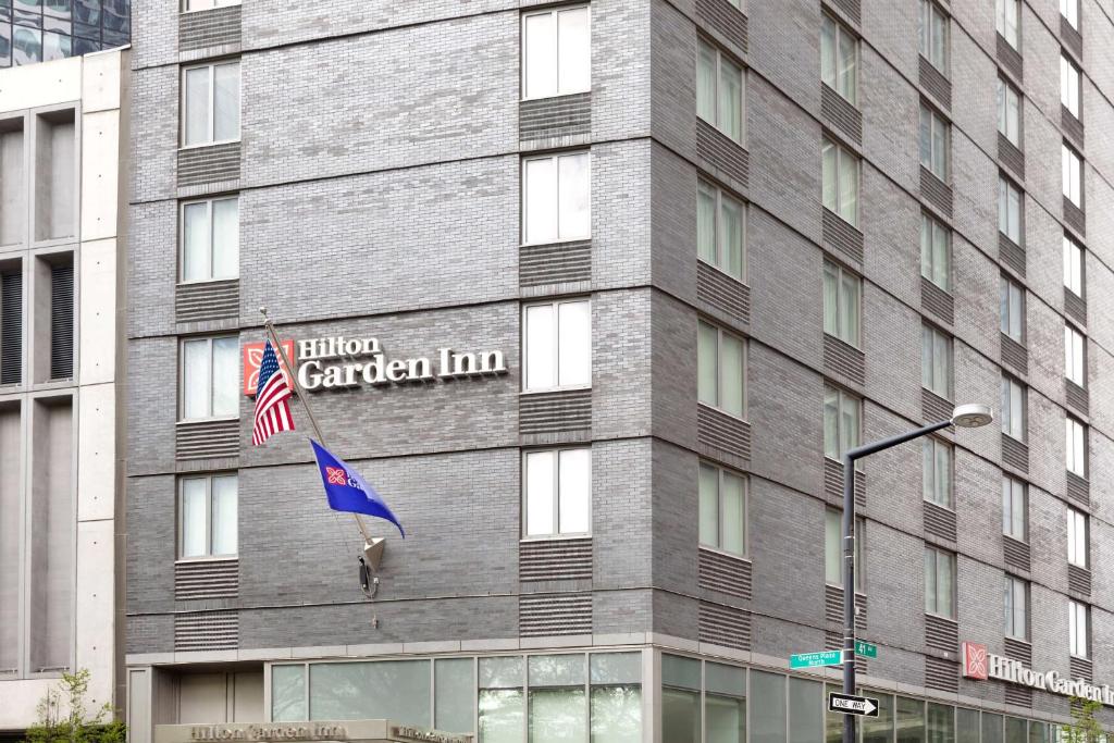 皇后區的住宿－Hilton Garden Inn Long Island City，一面有旗帜的建筑