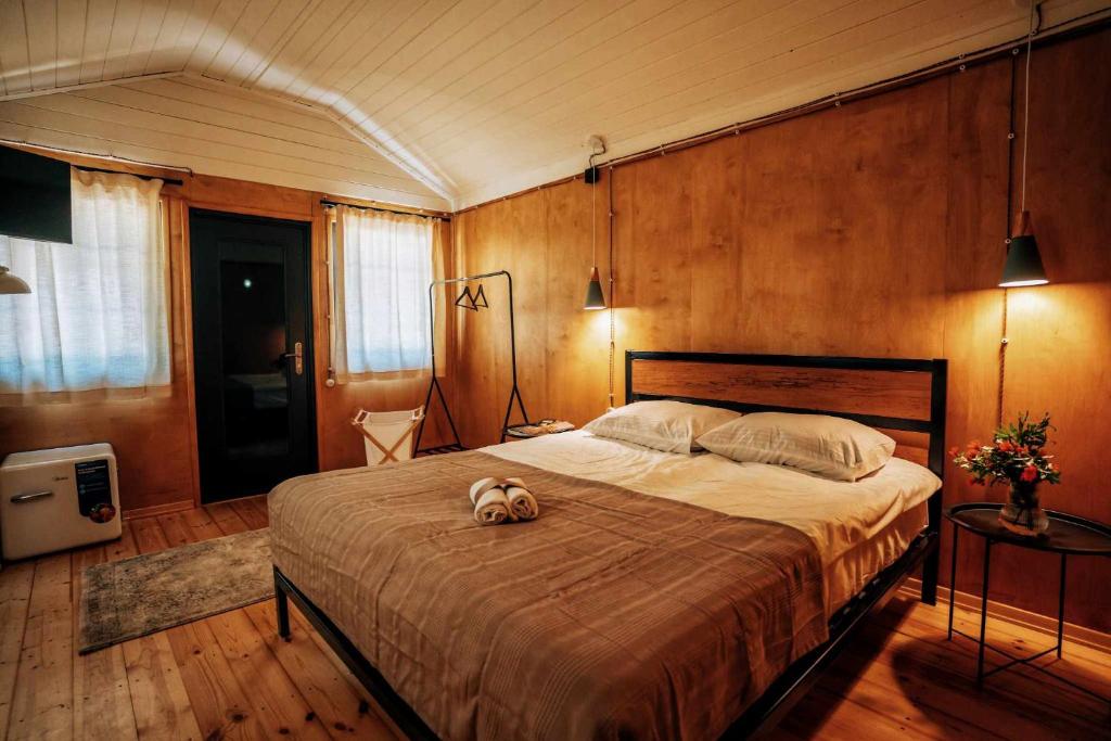 a dog laying on a bed in a bedroom at Brotseulebi in Ambrolauri