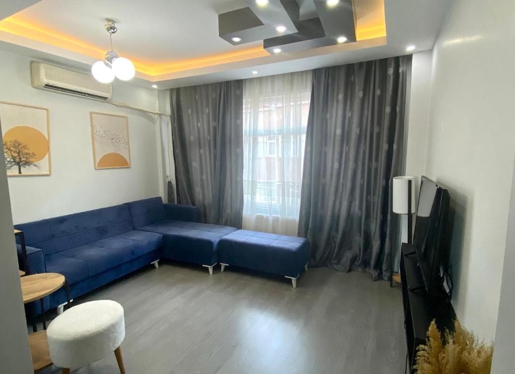 a living room with a blue couch and a window at Newly Refurbished 2 Bedroom Apartment in the Heart of Istanbul in Istanbul