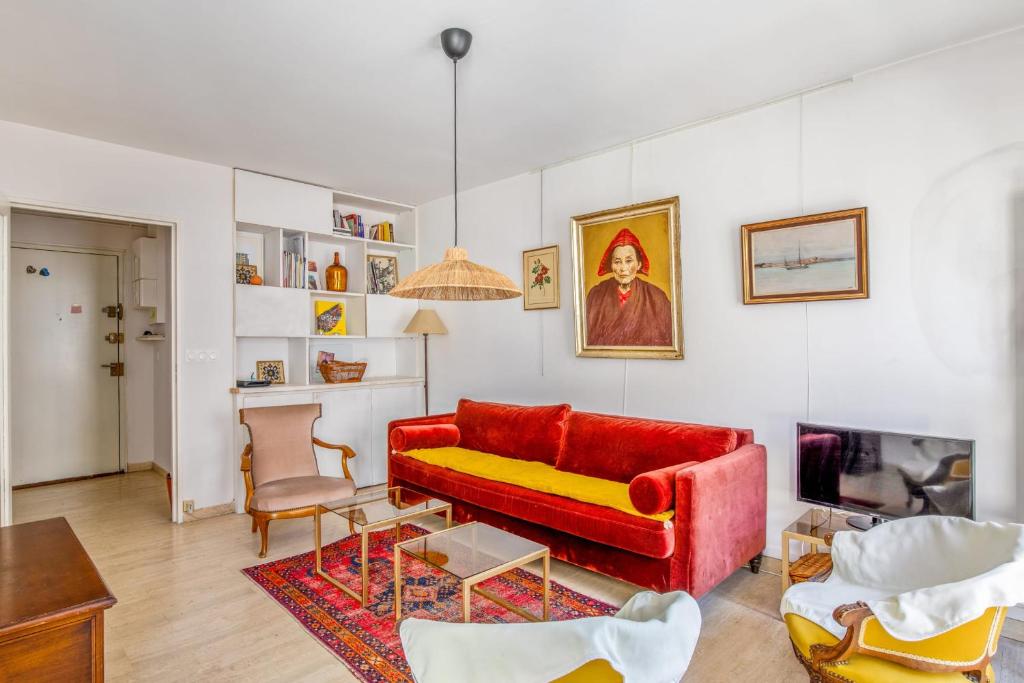 un salon avec un canapé rouge et une table dans l'établissement Appartement Molière - Welkeys, à Avignon