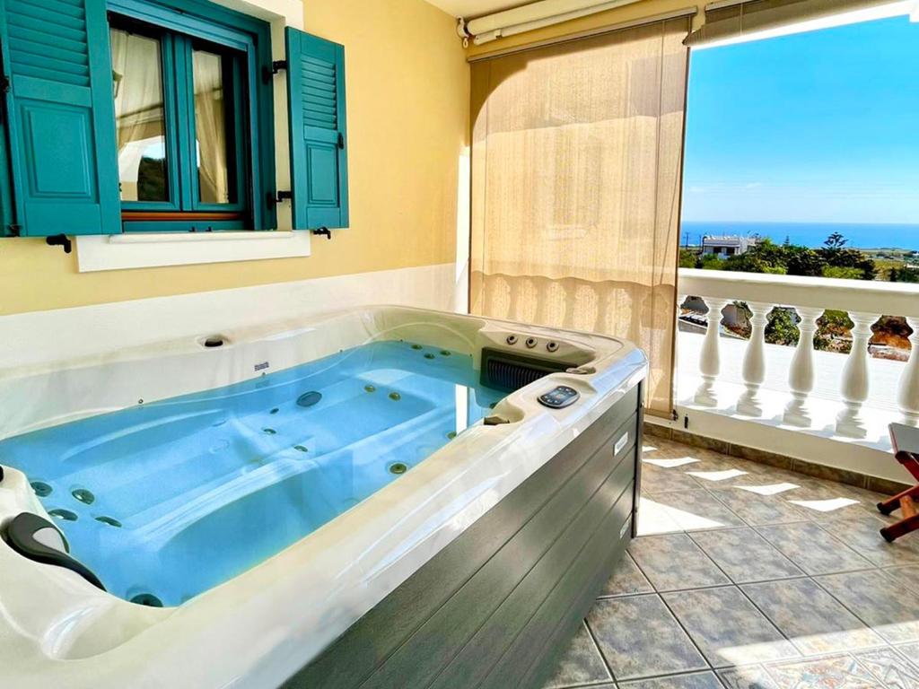 una vasca idromassaggio in una stanza con finestra di Skarmoutsos Holiday Home a Vourvoúlos