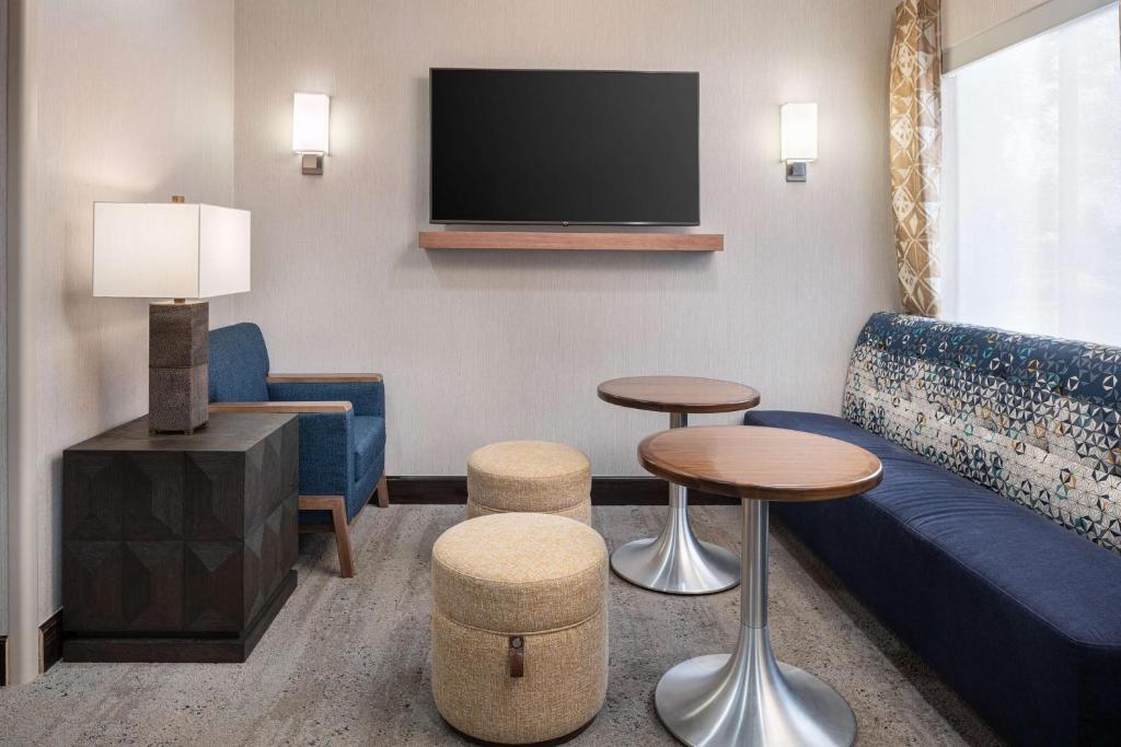 ein Wohnzimmer mit einem Sofa und einem TV in der Unterkunft Hampton Inn Boulder/Louisville in Louisville