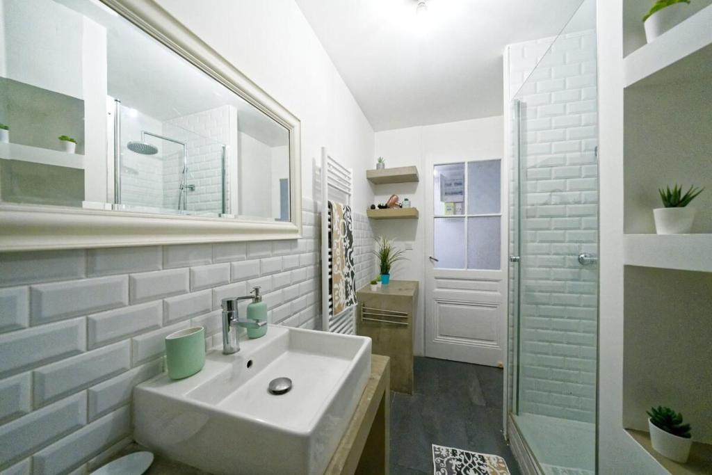 a white bathroom with a sink and a shower at Le Boudoir Vieux Lyon-Fourviere 4 pers in Lyon