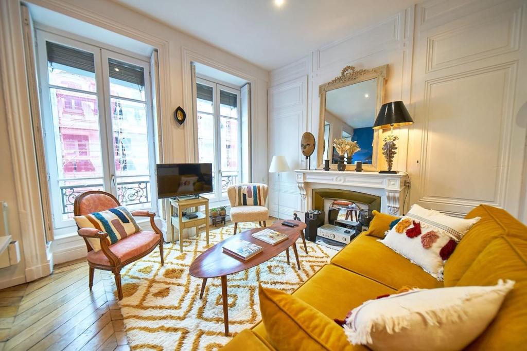 a living room with a yellow couch and a fireplace at Charmant cocon lyonnais Sathonay-Terreaux in Lyon