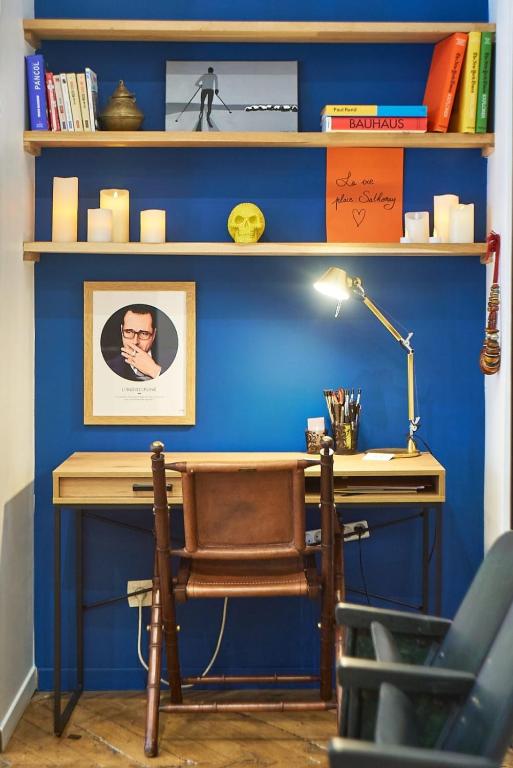 a desk with a chair next to a blue wall at Charmant cocon lyonnais Sathonay-Terreaux in Lyon