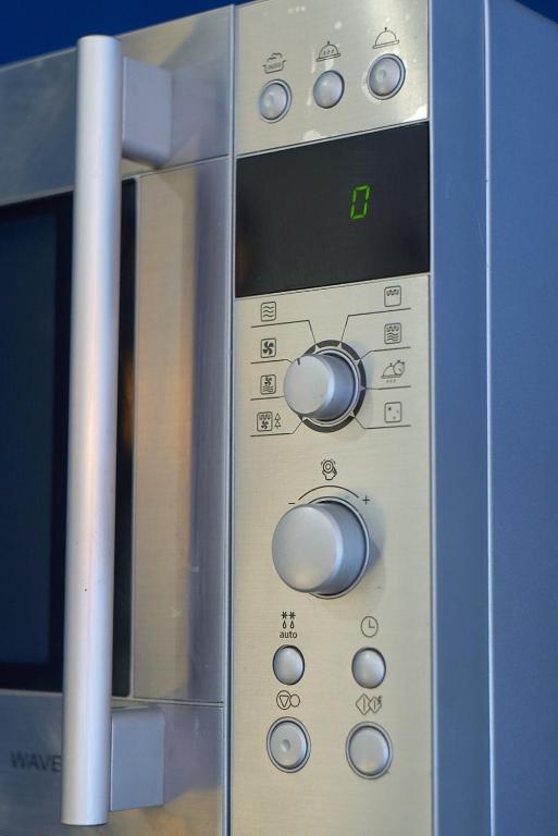 a close up of a microwave oven with control knobs at Charmant cocon lyonnais Sathonay-Terreaux in Lyon