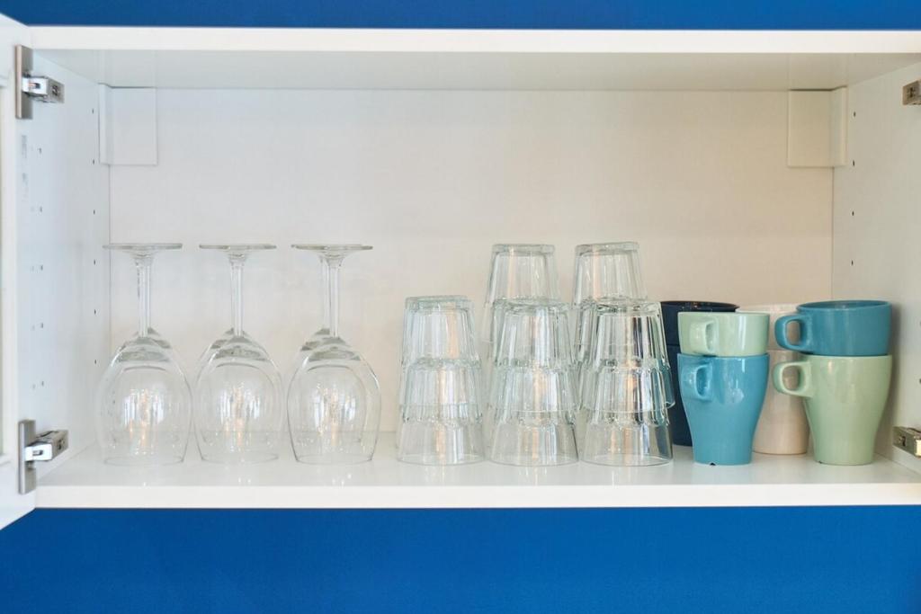 a shelf with glasses and cups on it at Charmant cocon lyonnais Sathonay-Terreaux in Lyon