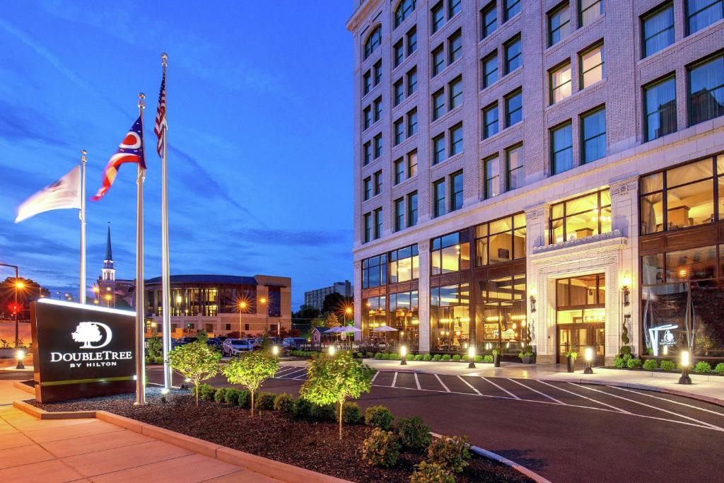Un edificio con dos banderas delante. en Doubletree By Hilton Youngstown Downtown, en Youngstown