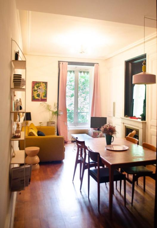 a living room with a table and a couch at Chez Julie -métro Garibaldi- Université in Lyon