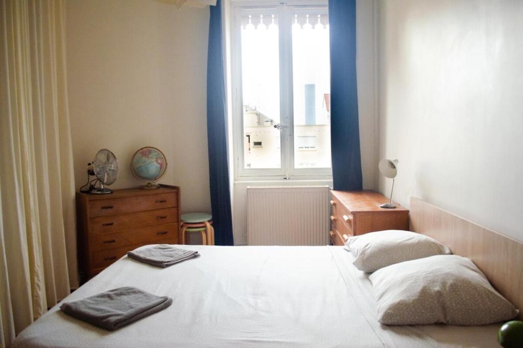 a bedroom with a white bed and a window at Chez Julie -métro Garibaldi- Université in Lyon