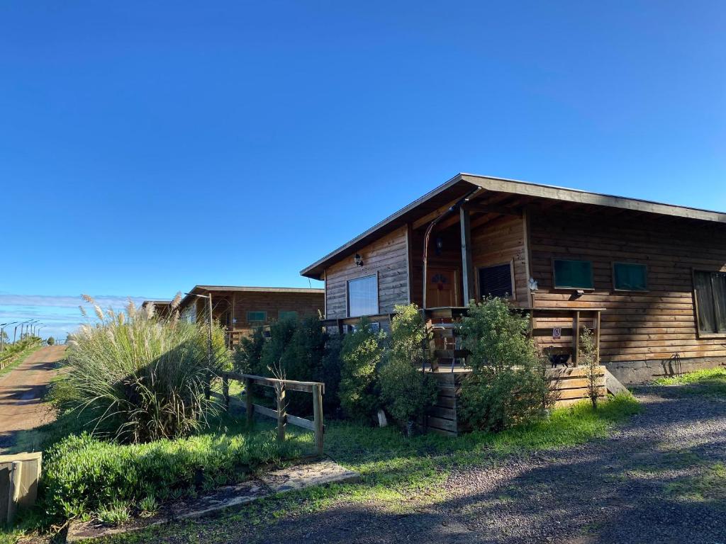 una casa de madera al lado de una playa en Cabañas y Centro Eventos Leyda, en San Antonio