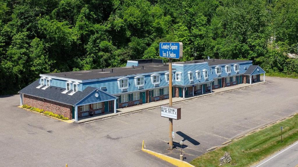 a blue building in a parking lot with a street sign at Country Squire inn and suites in Coshocton