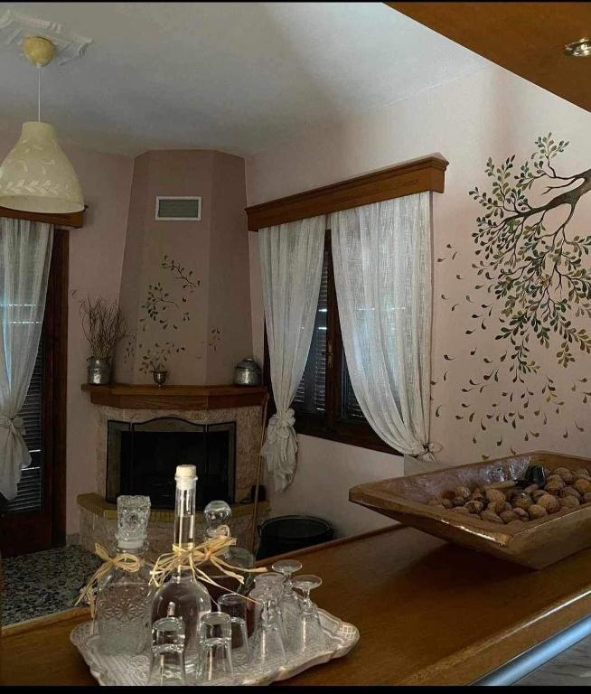 a kitchen with a counter top with a table with a fireplace at Άγρια Λούλουδα Κατοικία Ευτυχία in Timfristós