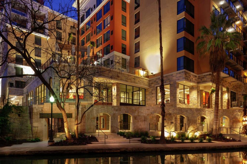 un edificio por la noche con un reflejo en el agua en Hampton Inn & Suites San Antonio Riverwalk, en San Antonio