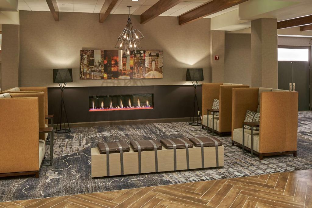 a lobby with a fireplace in a waiting room at Hilton Cincinnati Airport in Florence