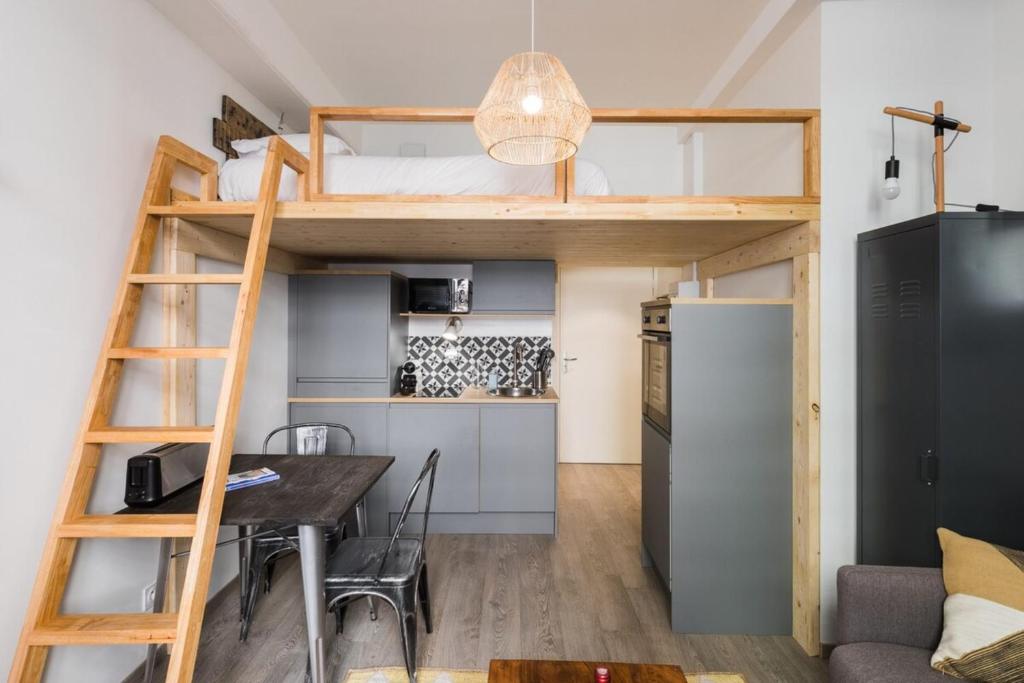 a loft bed in a room with a table and a refrigerator at Joli 2 pers- Croix Rousse-Chartreux in Lyon