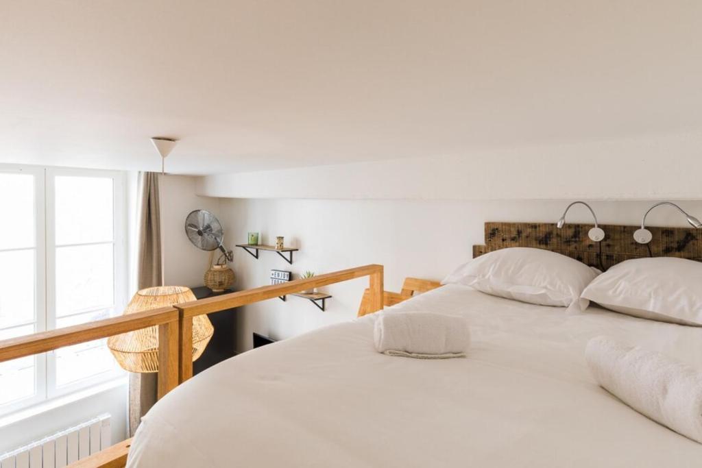 a bedroom with a bed with white sheets and a window at Joli 2 pers- Croix Rousse-Chartreux in Lyon