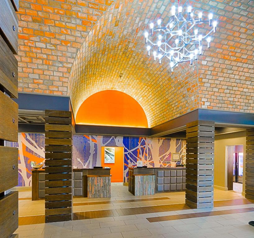 a lobby with a brick wall and a chandelier at Embassy Suites by Hilton Denver Central Park in Denver