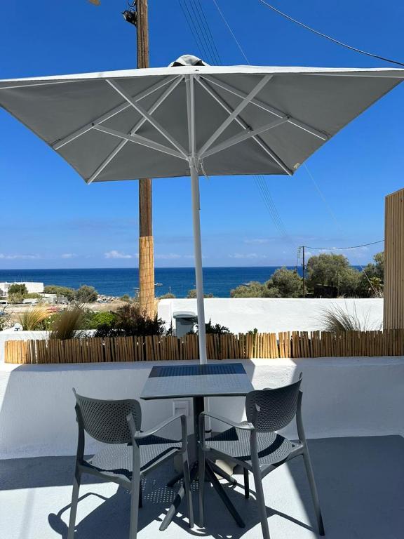 a table and two chairs under an umbrella at Kamara Sea View Junior Suite in Kamari