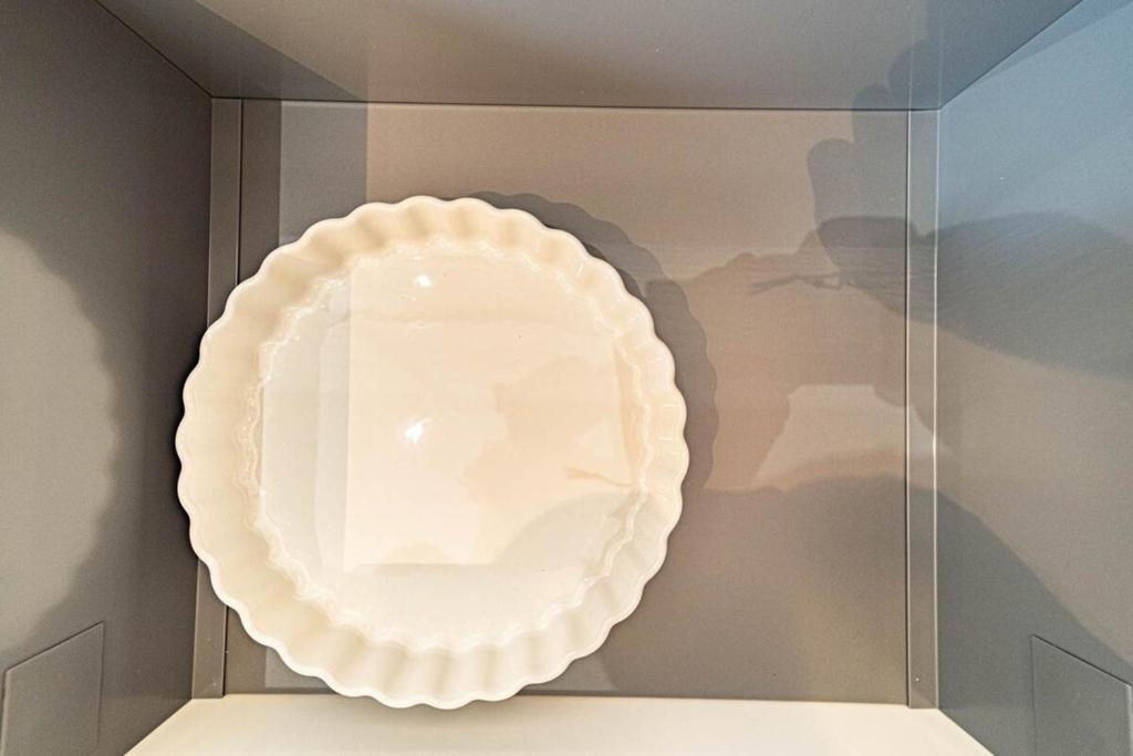 a white plate on a glass display case at Le petit Montel- studio avec garage-métro Valmy in Lyon