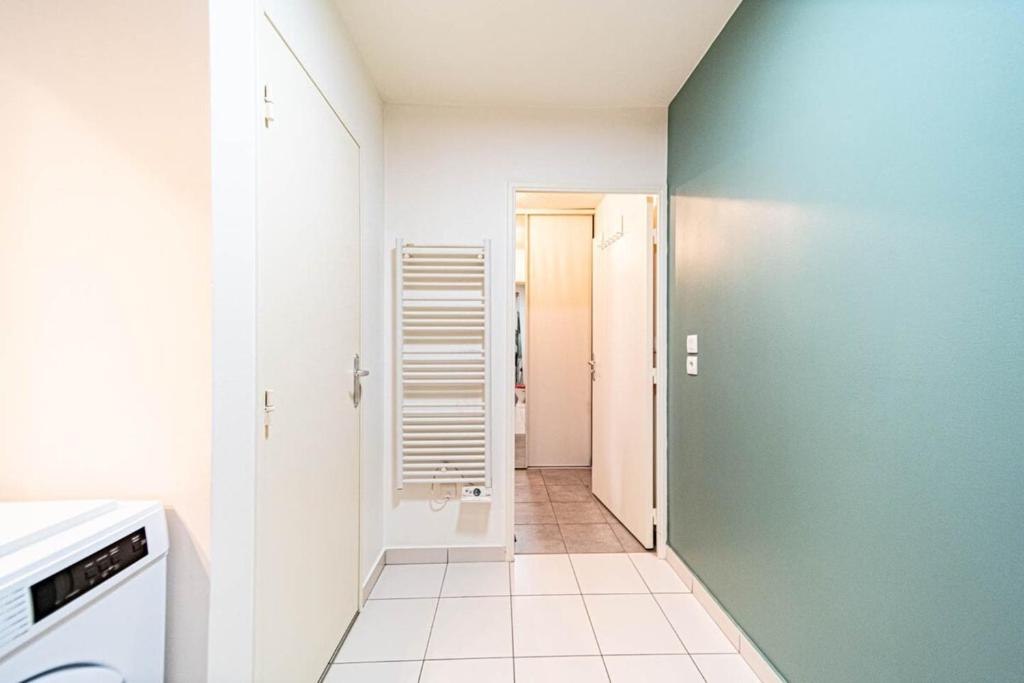 a bathroom with a green wall and a hallway at Le petit Montel- studio avec garage-métro Valmy in Lyon