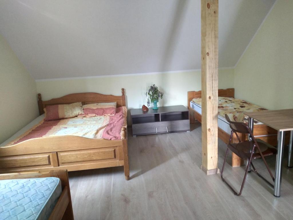 1 dormitorio con 2 camas, escritorio y mesa en Agroturystyka Zacisze nad Pilicą, en Stromiec