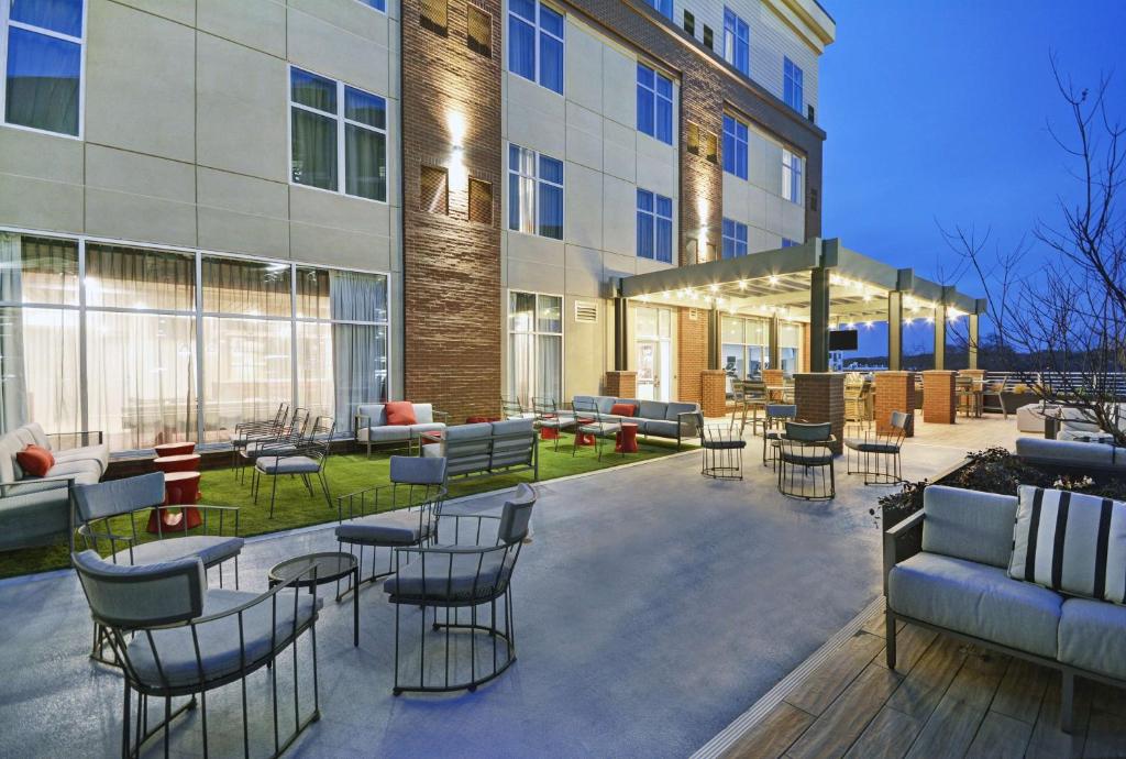 a patio with chairs and tables in front of a building at Homewood Suites by Hilton Athens Downtown University Area in Athens