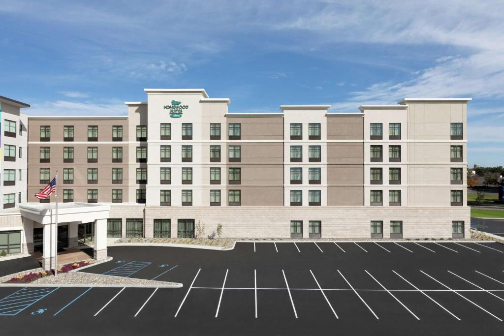 an exterior view of a hotel with a parking lot at Homewood Suites by Hilton Albany Crossgates Mall in Albany