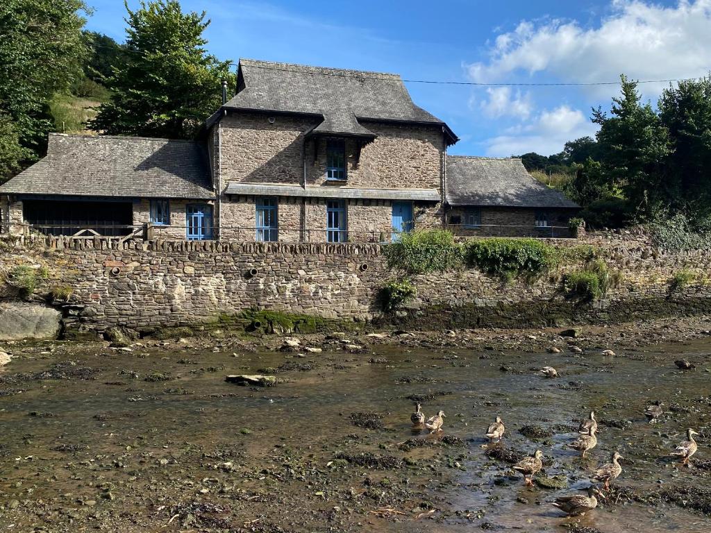 ein altes Haus mit Enten im Wasser davor in der Unterkunft Bridgend Barn in Plymouth