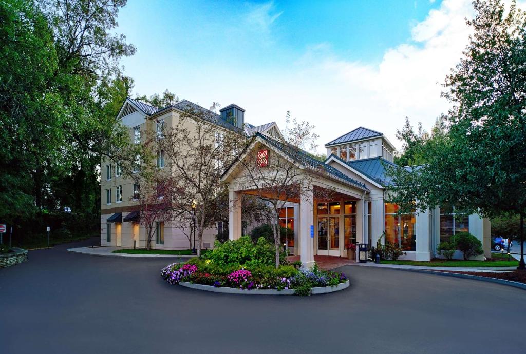 a large building with flowers in front of it at Hilton Garden Inn Saratoga Springs in Saratoga Springs