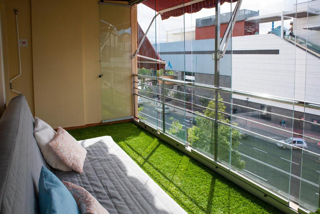 サンタクルス・デ・テネリフェにあるSanta Cruz Luxe Apartmentのベッド1台と大きな窓が備わる客室です。