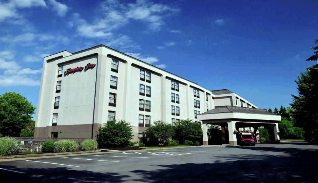 um grande edifício branco com estacionamento em Hampton Inn Albany-Wolf Road em Albany