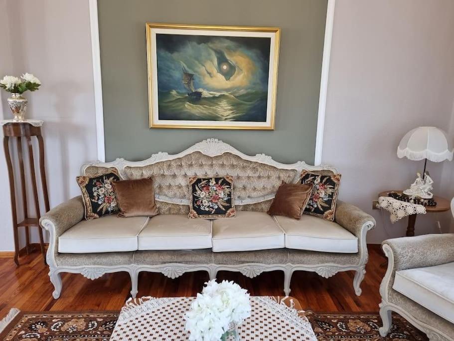 a living room with a couch and a painting at ΚΤΗΜΑ ΜΠΟΡΑΒΟΥ in Kastoria
