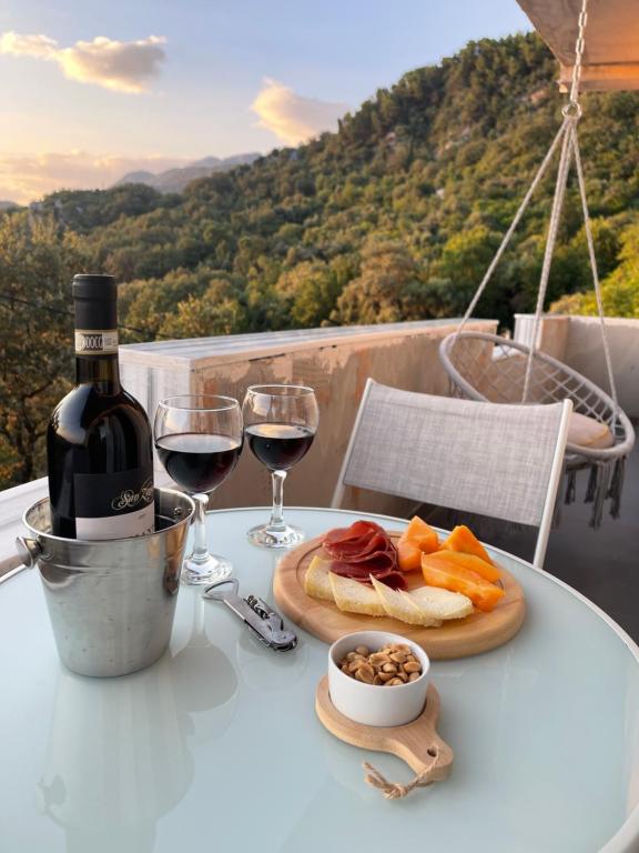 a table with a glass of wine and a plate of food at Apartments Tijana in Budva