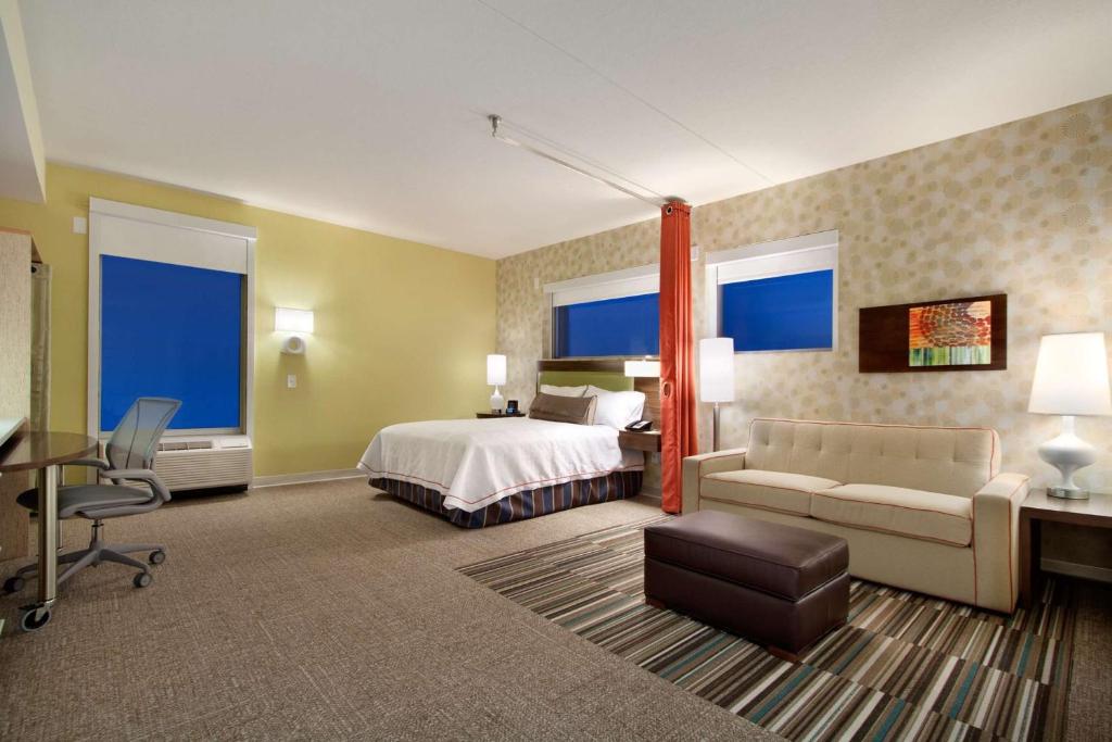 a large hotel room with a bed and a couch at Home2 Suites by Hilton - Oxford in Oxford