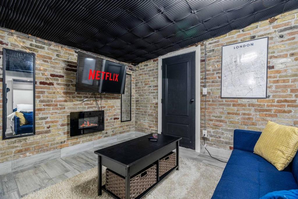 a living room with a blue couch and a tv at London Downtown Home in London