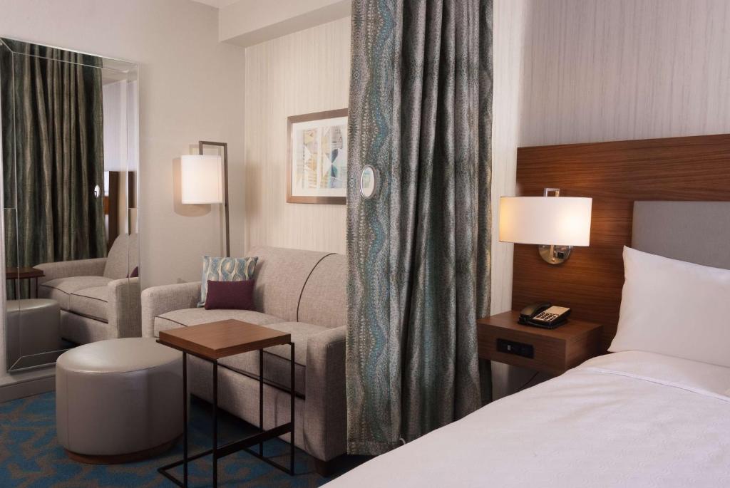 a hotel room with a bed and a couch at Home2 Suites By Hilton Atlanta Perimeter Center in Atlanta