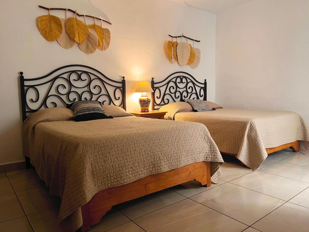 duas camas sentadas num quarto com em LAS ALAMEDAS Departamentos céntricos con estacionamiento privado em Guanajuato