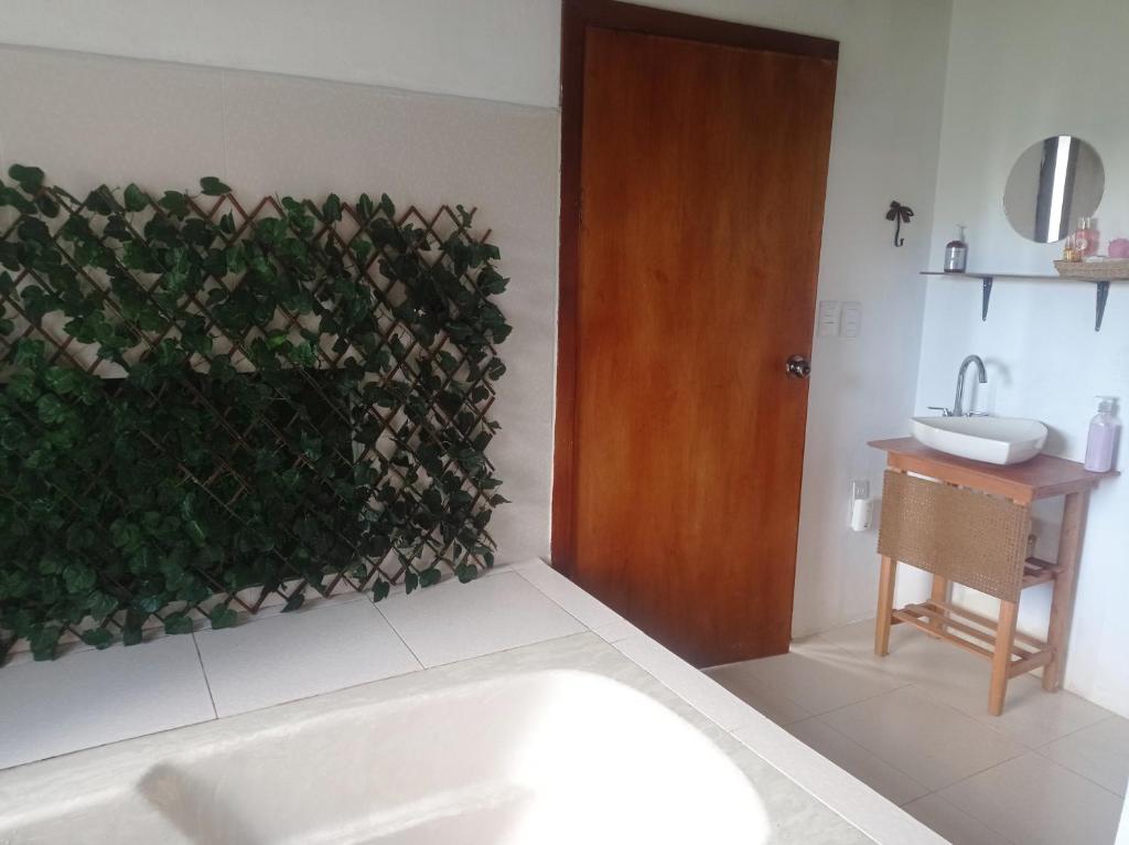a bathroom with a green wall with a tub and a sink at Vista Hermosa Suite 