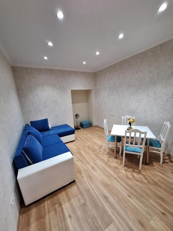 uma sala de estar com um sofá azul e uma mesa em Mery's Family Apartment em Tbilisi