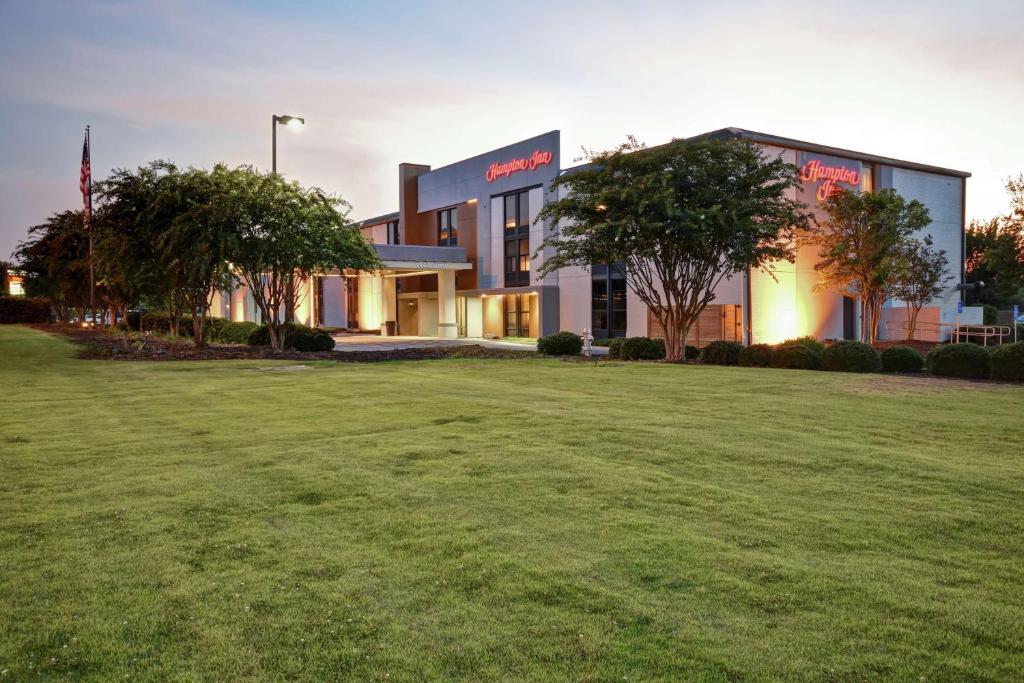 a building with a large lawn in front of it at Hampton Inn Auburn in Auburn