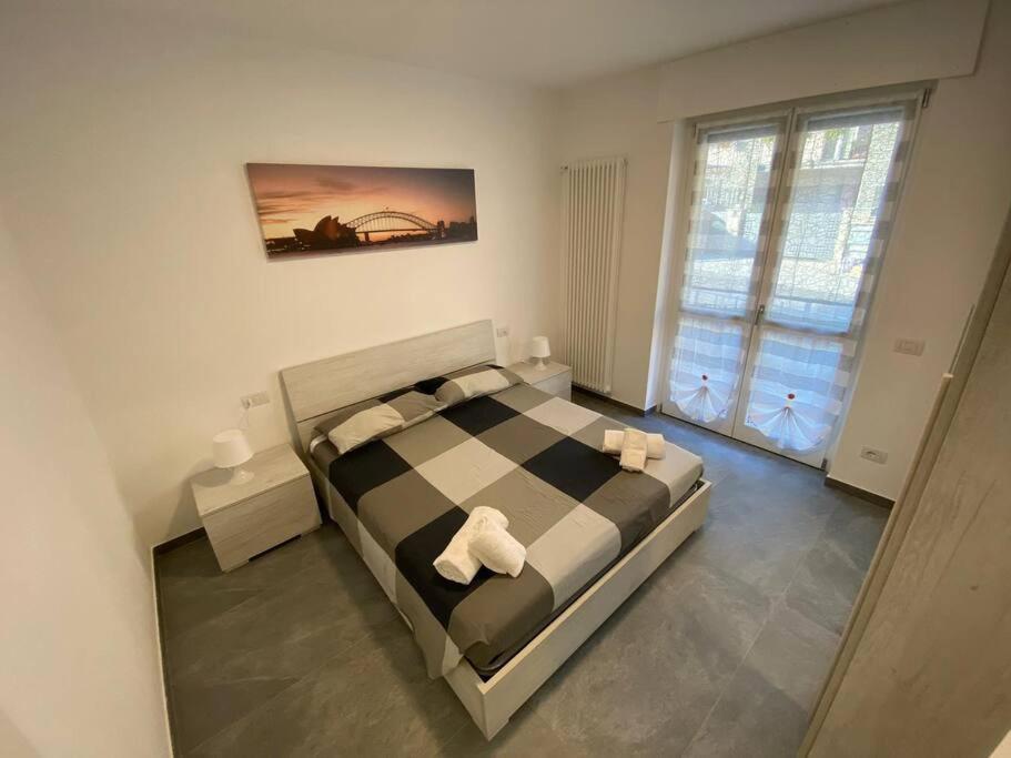 1 dormitorio con 1 cama a cuadros y 2 toallas blancas en Casa Mattia, en Bellano