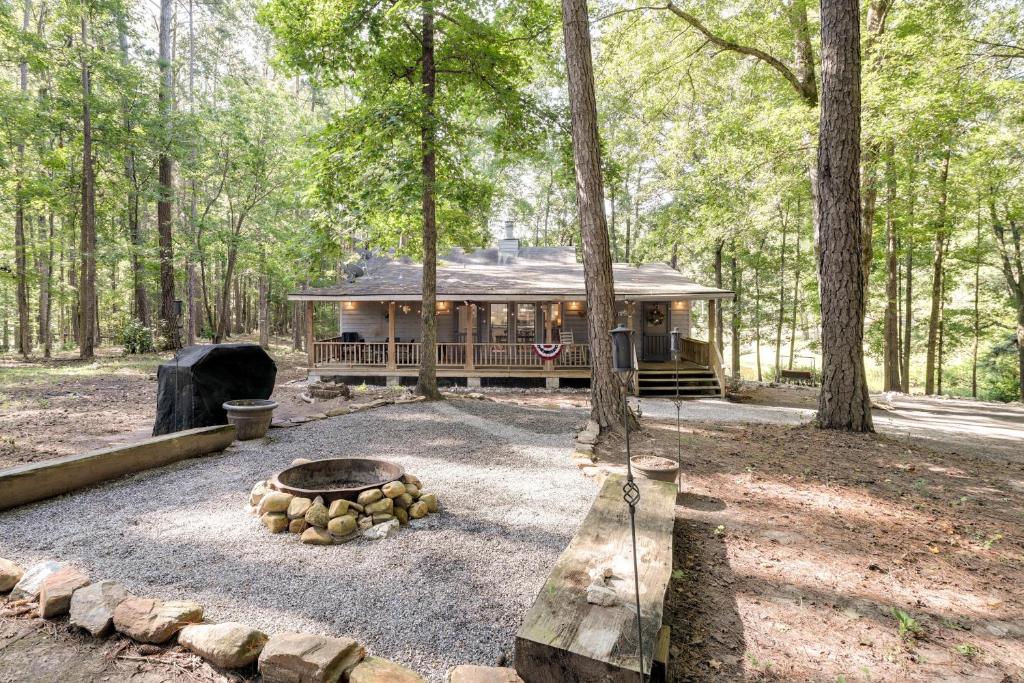 una cabaña en el bosque con una hoguera en Secluded Hamilton Cabin Retreat with Private Lake!, en Hamilton