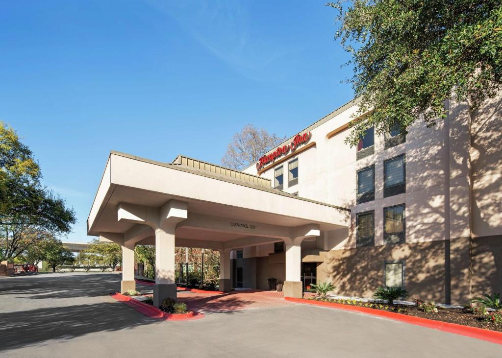 a building with an awning next to a street at Hampton Inn Austin North in Austin