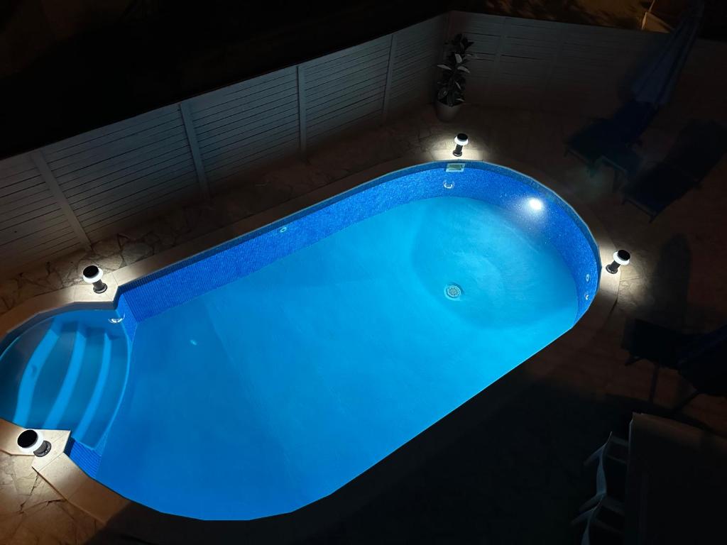 Katie's Luxury Place في بلاتانياس: حوض استحمام أزرق كبير مع أضواء حوله