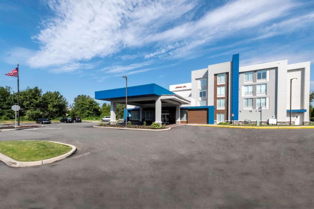 un hotel con un estacionamiento delante de él en Hampton Inn Swedesboro Philadelphia en Swedesboro