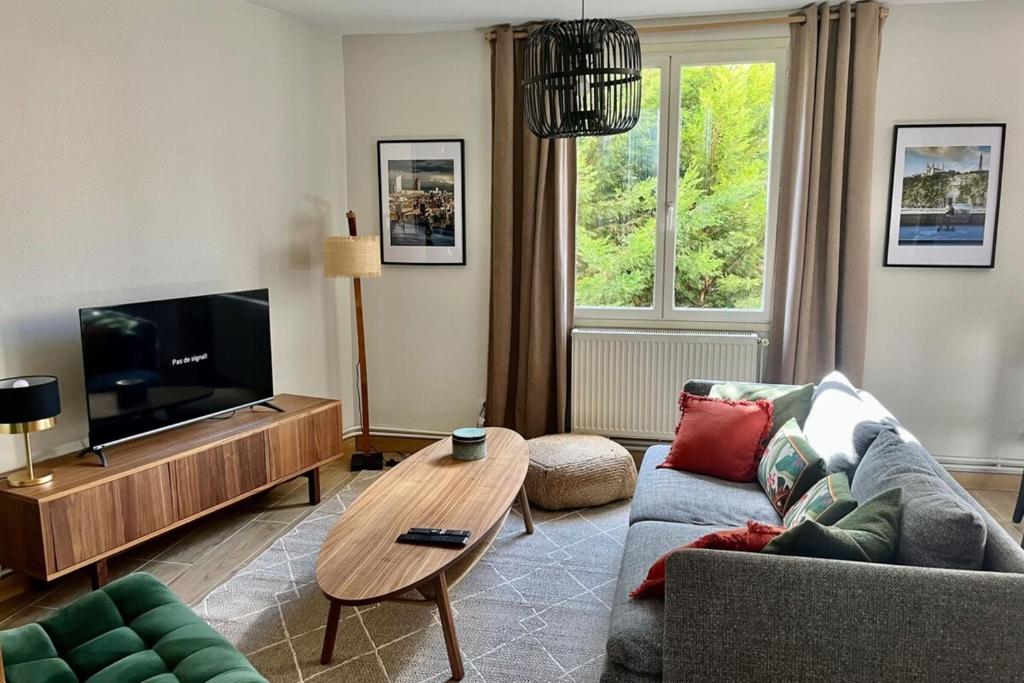 un salon avec un canapé et une télévision dans l'établissement Le Perralieres charmant 2 chambres métro Flachet, à Villeurbanne