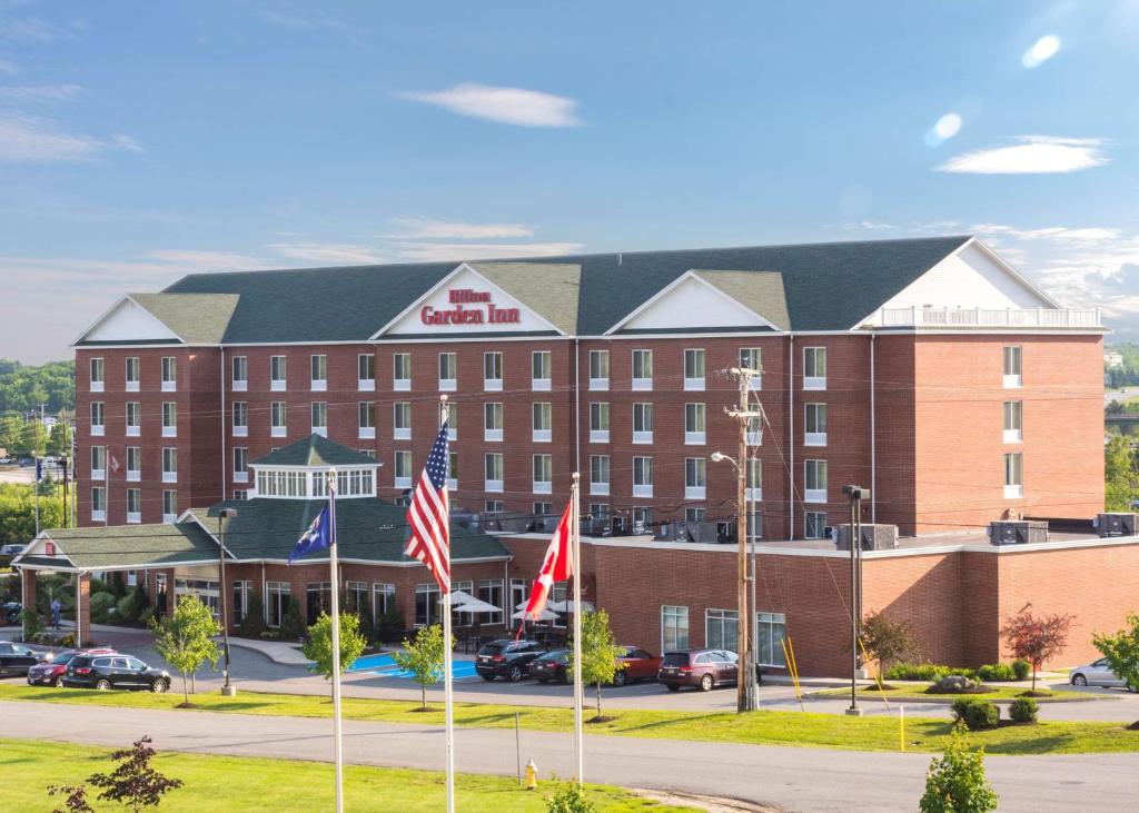 ein Hotelgebäude mit Flaggen davor in der Unterkunft Hilton Garden Inn Bangor in Bangor